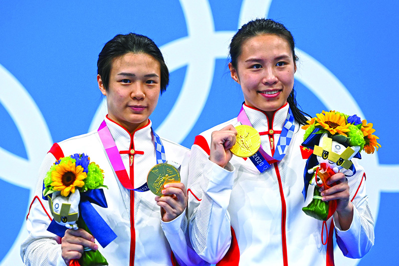 TOKYO: China's Shi Tingmao (left) and Wang Han pose with their gold medals on the podium after winning the women's synchronized 3m springboard diving final event during the Tokyo 2020 Olympic Games at the Tokyo Aquatics Center in Tokyo yesterday. – AFPnn