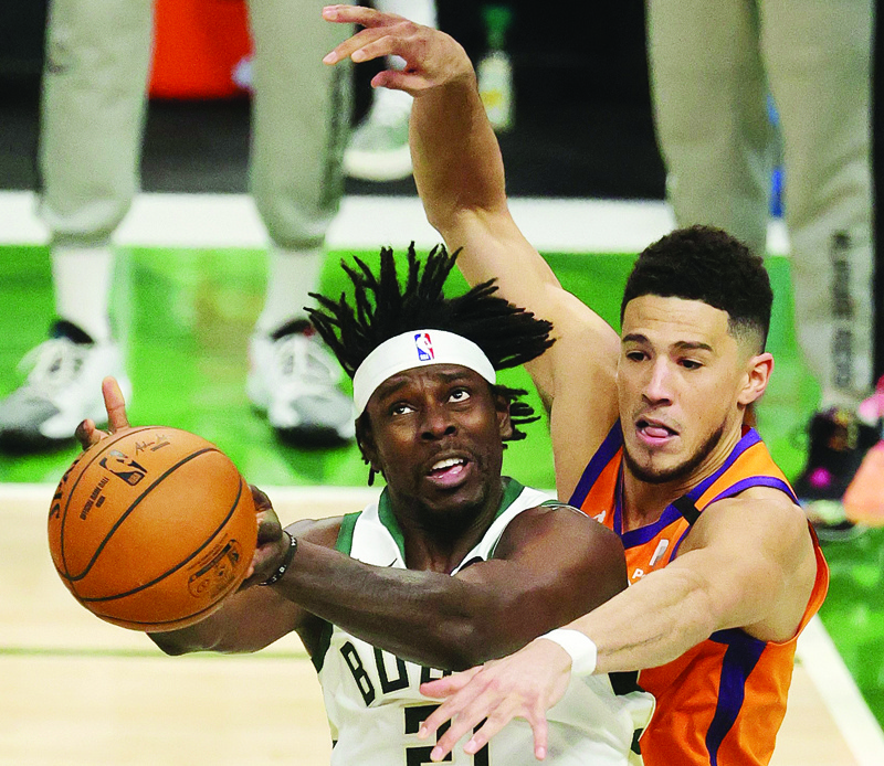 MILWAUKEE: Jrue Holiday #21 of the Milwaukee Bucks is defended by Devin Booker #1 of the Phoenix Suns during the second half in Game Four of the NBA Finals at Fiserv Forum on Wednesday. - AFP n