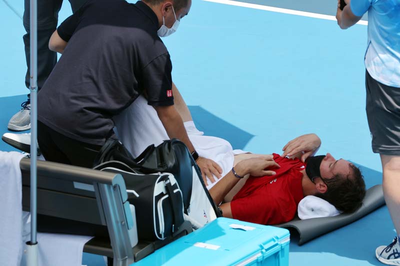 TOKYO: Russia's Daniil Medvedev is assisted by a physio during Tokyo 2020 Olympic Games men's singles third round tennis match against Italy's Fabio Fognini at the Ariake Tennis Park in Tokyo yesterday. – AFPn
