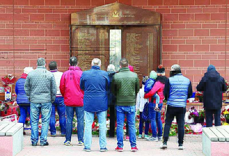 LIVERPOOL: In this file photo taken on April 15, 2019, people gather in front of the Hillsborough memorial outside Liverpool Football Club's main stand at Anfield to commemorate the 30th anniversary of the Hillsborough football stadium disaster. - AFP n