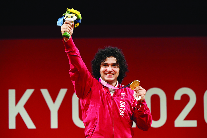 TOKYO: Gold medalist Qatar's Fares El-Bakh poses on the podium for the victory ceremony of the men's 96kg weightlifting competition during the Tokyo 2020 Olympic Games at the Tokyo International Forum in Tokyo yesterday. - AFPn