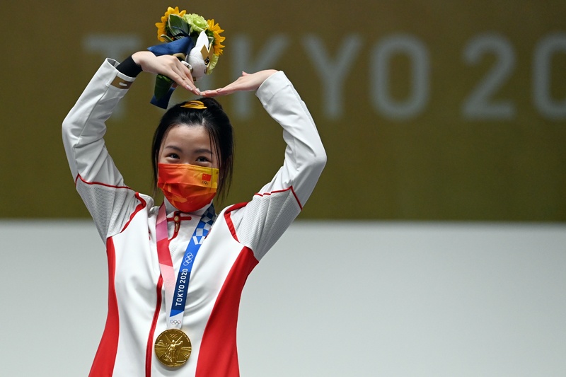 TOKYO: Gold medal winner China's Yang Qian celebrates on the podium after winning the women's 10m air rifle final during the Tokyo 2020 Olympic Games at the Asaka Shooting Range in the Nerima district of Tokyo yesterday. – AFPn