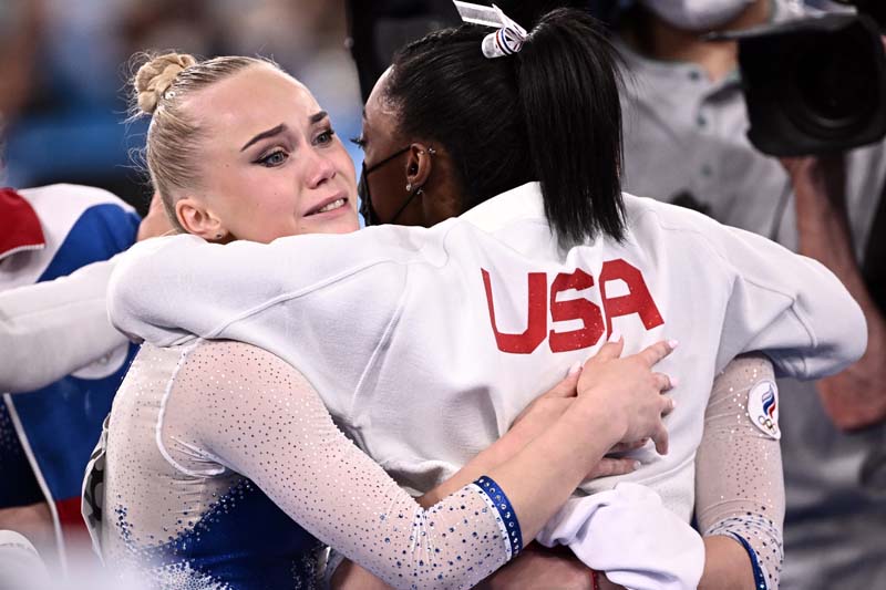 TOKYO: Russia's Angelina Melnikova (left) is congratulated by USA's Simone Biles as Russia wins the artistic gymnastics women's team final during the Tokyo 2020 Olympic Games at the Ariake Gymnastics Center in Tokyo yesterday. - AFPn