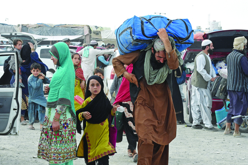 CHAMAN: Pakistani people return from Afghanistan after crossing the border point in Pakistan's town of Chaman yesterday, as Pakistan partially reopened its southern crossing with Afghanistan, shut off since the Taleban seized control of the strategic border town on the other side.  - AFPnn