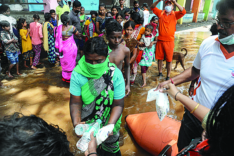 SANGLI: India's National Disaster Response Force (NDRF), personnel distribute food and relief materials to people in areas inundated with flood waters at Sangli district of Maharashtra. - AFPn