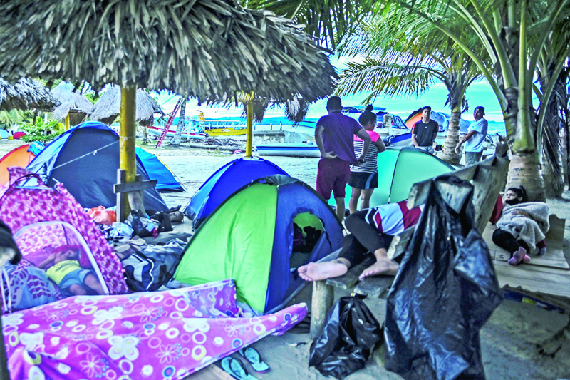 NECOCLI, Colombia: Stranded migrants from Venezuela camp on the beach in Necocli, Colombia. Thousands of migrants go through Necocli's small pier in their weeks-long journey from South America to the US. - AFPn