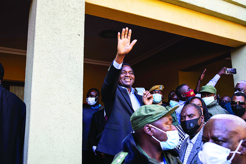 LUSAKA: President elect Hakainde Hichilema (C) waves at supporters after a press briefing at his residence in Lusaka. Zambian business tycoon and veteran opposition leader Hakainde Hichilema scored a landslide victory in bitterly-contested presidential elections. - AFPn