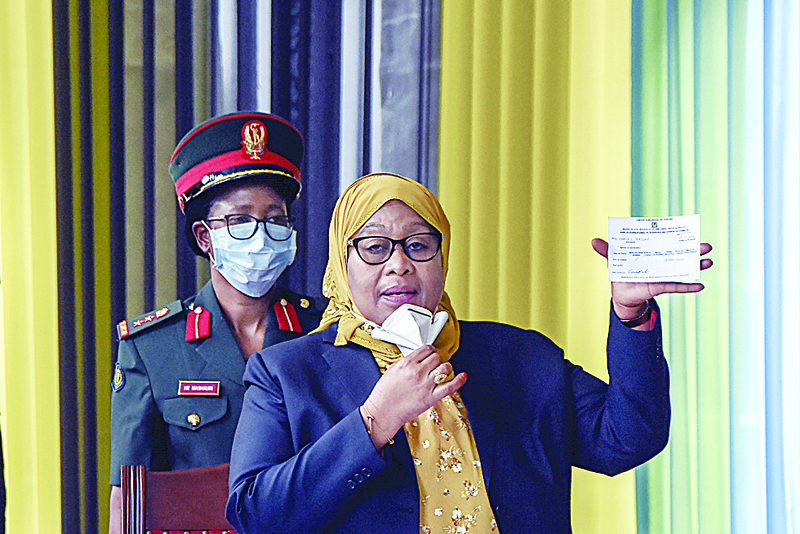 DAR ES SALAAM: Tanzania's President Samia Suluhu Hassan shows a vaccination certificate after she received a shot of the Johnson & Johnson vaccine from a health worker at the State House in Dar es Salaam.-AFPn