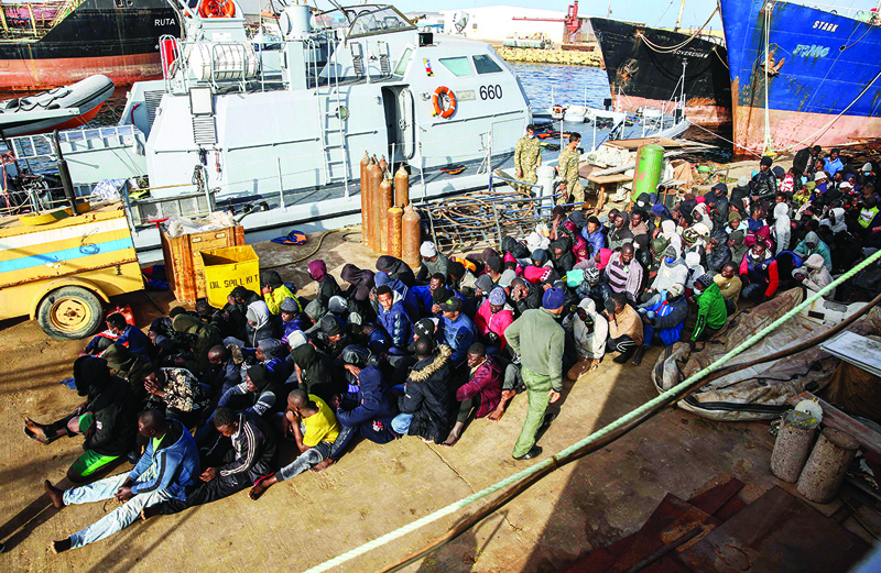 TRIPOLI: File photo shows migrants rescued off the coast of al-Khums, about 120 kilometres east of the capital, sit on the pier in Tripoli's naval base. - AFPn