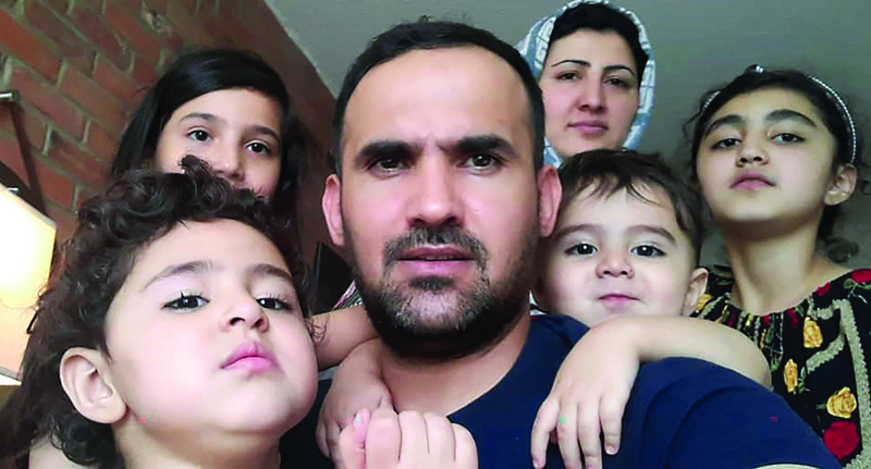 TORONTO: Mohammad Ehsan Saadat, a 33-year-old Afghan who recently arrived in Canada, poses with his wife and children on Tuesday. - AFP n