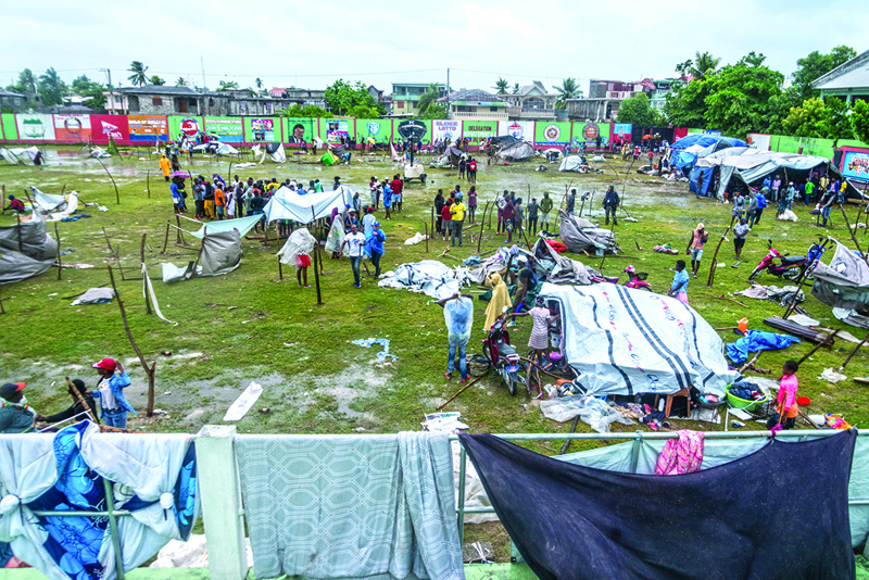 LES CAYES, Haiti: People make repairs and create shelter, after spending the night outside in the aftermath of the earthquake, facing the severe inclement weather of Tropical Storm Grace near Les Cayes, Haiti Tuesday.-AFPn