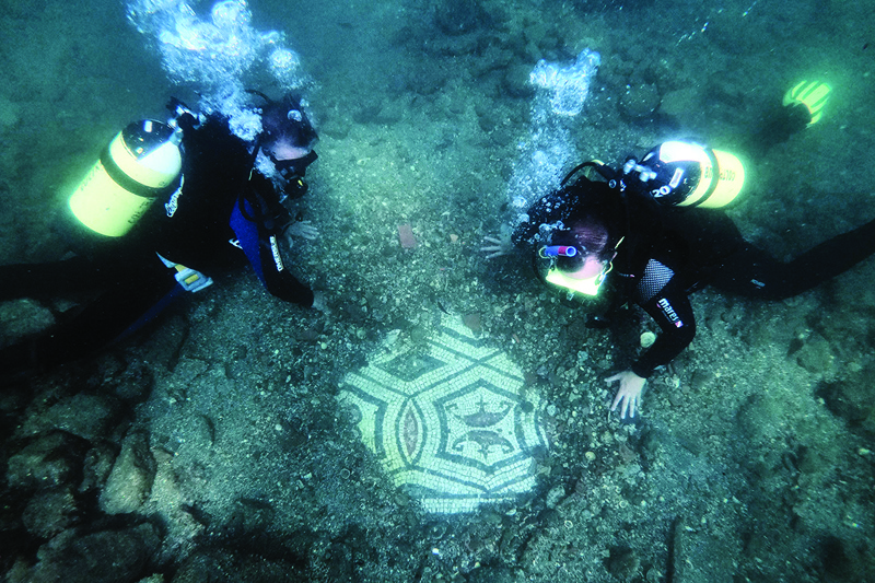 In this photograph a dive guide shows tourists a mosaic from Terme del Lacus, the submerged ancient Roman city of Baiae at the Baiae Underwater Park, part of the Campi Flegrei Archaeological Park complex site in Pozzuoli near Naples.—AFP photosn