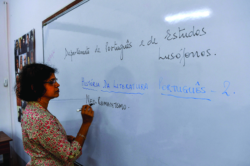 In this photograph Lorraine Alberto, professor of Portuguese language at Goa University, writes on a whiteboard as she leads an online class at Panaji in Goa. — AFP photosn
