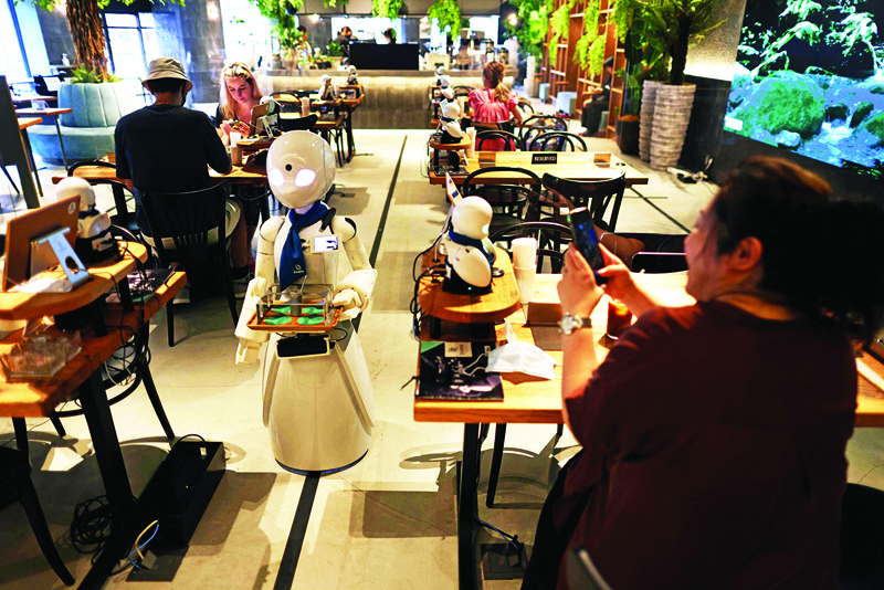 In this picture a humanoid robot delivers drinks to customers at the Dawn Cafe in Tokyo.—AFP photosn