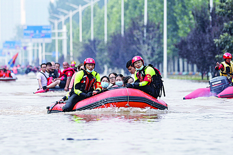 Rescuers of the fire and rescue department from China's eastern city of Yangzhou evacuating people from a hospital following heavy rains in Zhengzhou in China's Henan province. - AFPn