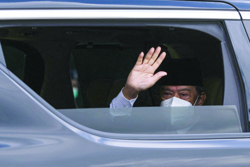 KUALA LUMPUR: Malaysia's Prime Minister Muhyiddin Yassin waves as he arrives at the National Palace in Kuala Lumpur, as he was expected to quit after just 17 months in office.-AFP n