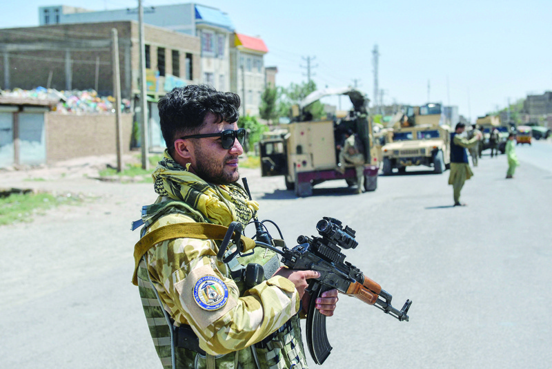 HERAT: An Afghan National Army commando stands guard along the road in the Enjil district of Herat province yesterday as skirmishes between Afghan National Army and Taleban continue. - AFP n