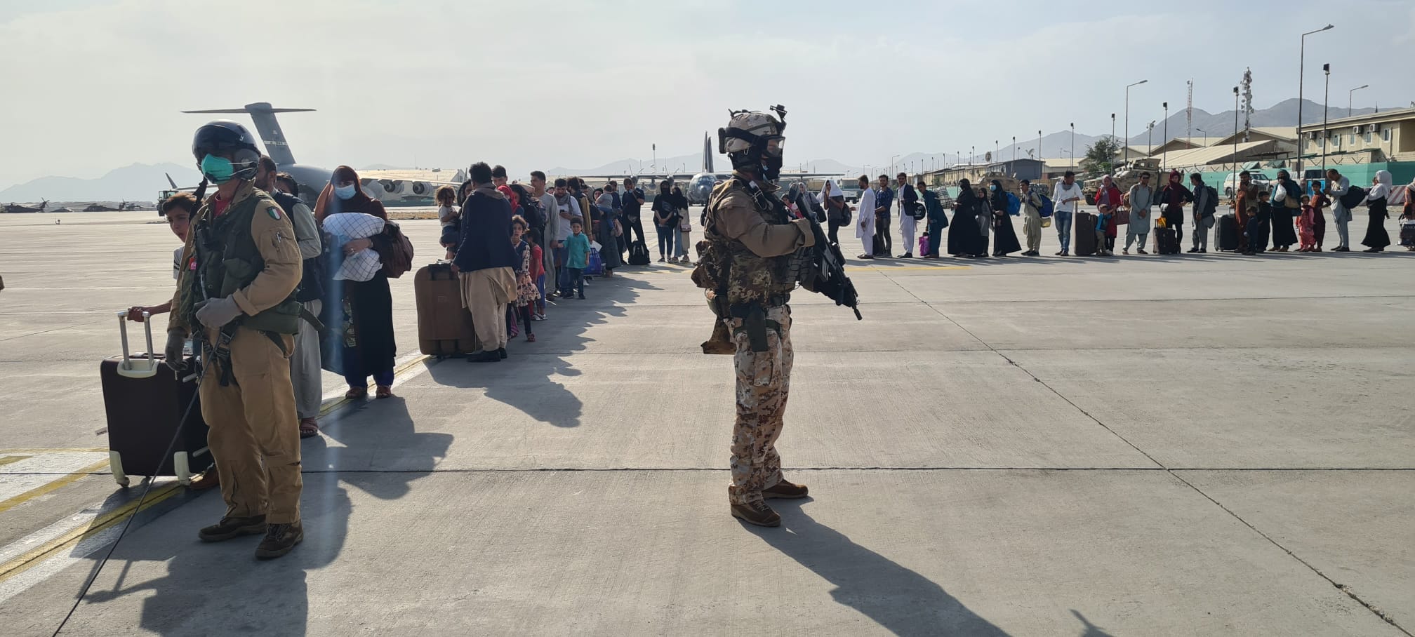 KABUL: This handout picture released and taken by the Italian Defense press office yesterday shows soldiers on the tarmac past passengers, who fled Afghanistan, waiting to board on an Italian military aircraft at Kabul airport, to fly to Rome Fiumicino. – AFPn