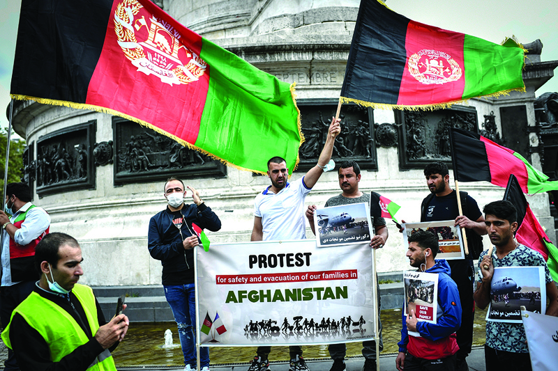 PARIS: Protesters wave the national Afghan flag and hold banners during a rally in support for Afghanistan following the takeover of the country by the Taliban, at Place de la Republique in Paris on Sunday. –AFPn