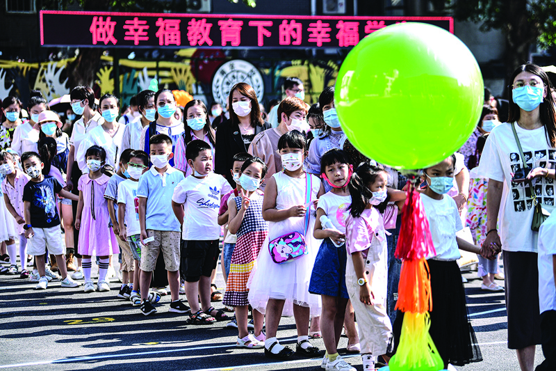 SHENYANG, China: First-year pupils arrive at a primary school for the new semester in Shenyang in China's northeastern Liaoning province yesterday. - AFPn