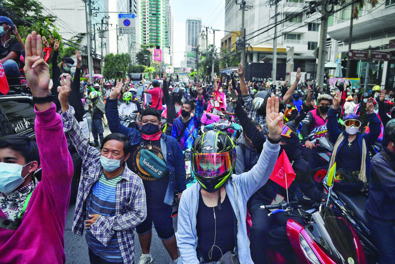 BANGKOK: Pro-democracy protesters salute during a car mob protest yesterday calling for the resignation of Thailand's Prime Minister Prayut Chan-O-Cha over the government's handling of the coronavirus crisis. - AFP  n