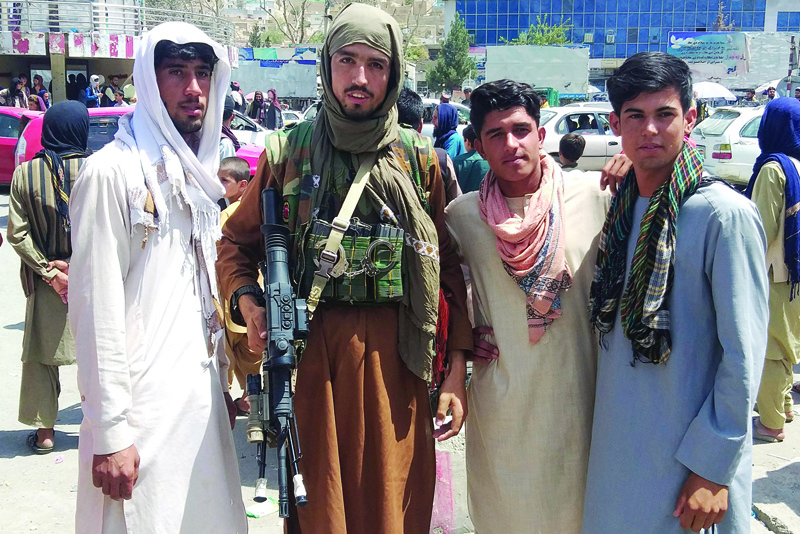 PUL-E-KHUMRI: A Taleban fighter is seen with locals yesterday after the Taleban captured the capital of Baghlan province. - AFP n