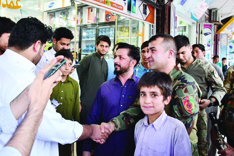 ZARANJ, Afghanistan: Sami Sadat (right), commander of the 215 Maiwand Afghan Army Corps, shakes hands with a local man in the city of Zaranj in Nimruz province. - AFPn