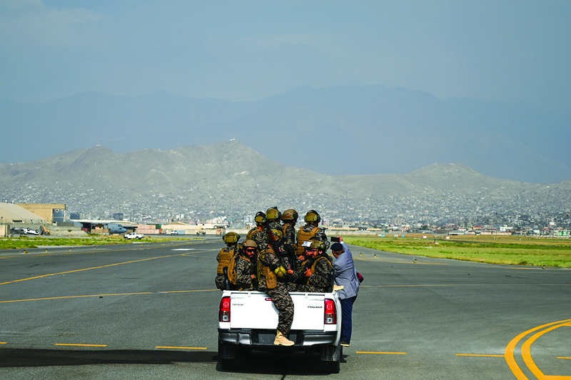 KABUL: Members of the Taleban Badri 313 military unit ride a vehicle on the runway of the airport in Kabul yesterday after the US has pulled all its troops out of the country to end a brutal 20-year war.—AFPn