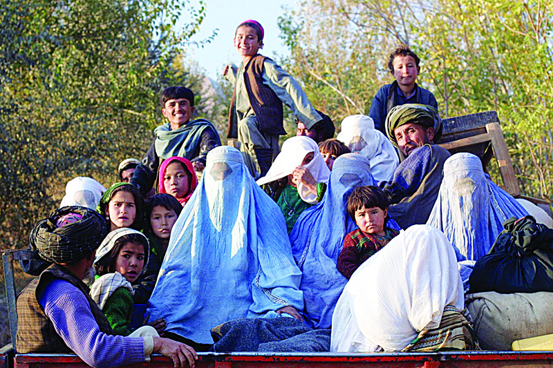 KALAQATA, Afghanistan : This file photo shows residents of the northeastern Afghan village of Kalaqata in Takhar province fleeing the frontline area as US fighter planes bomb Taleban positions nearby.-AFP n
