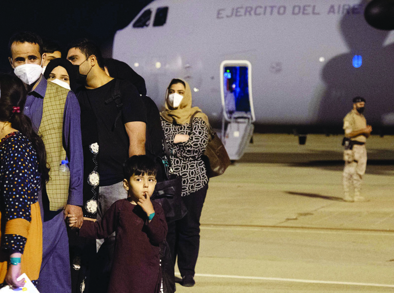 TORREJON DE ARDOZ AIR BASE: A group of Afghan nationals wait on the tarmac after disembarking from a first Spanish Air Force Airbus A400M carrying Spaniards who still remained in Afghanistan. - AFPn