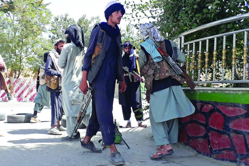 GHAZNI, Afghanistan: Taleban fighters stand along the roadside in Ghazni yesterday, as Taleban move closer to Afghan capital after taking Ghazni city. - AFP n