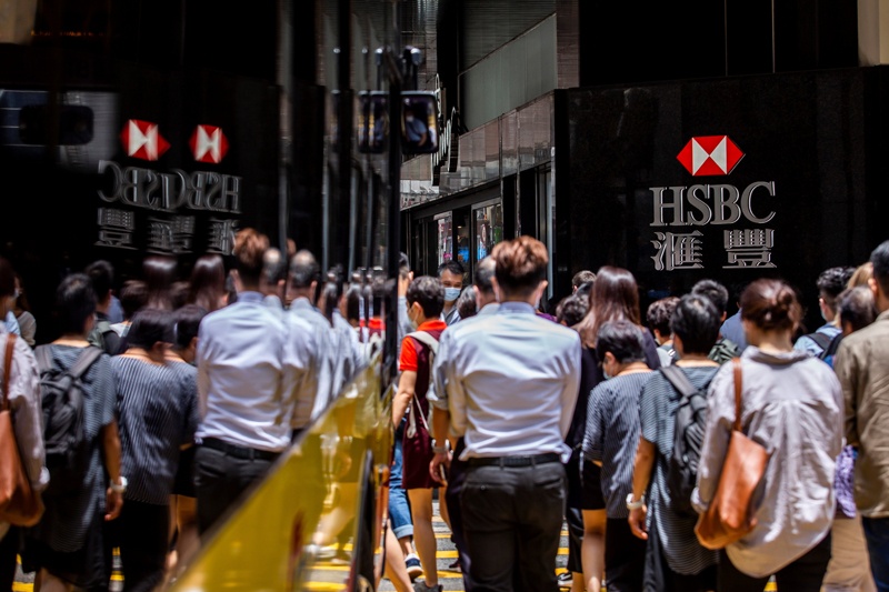 HONG KONG: Pedestrians walk past the logo for HSBC outside a local branch bank in Hong Kong yesterday. — AFPn