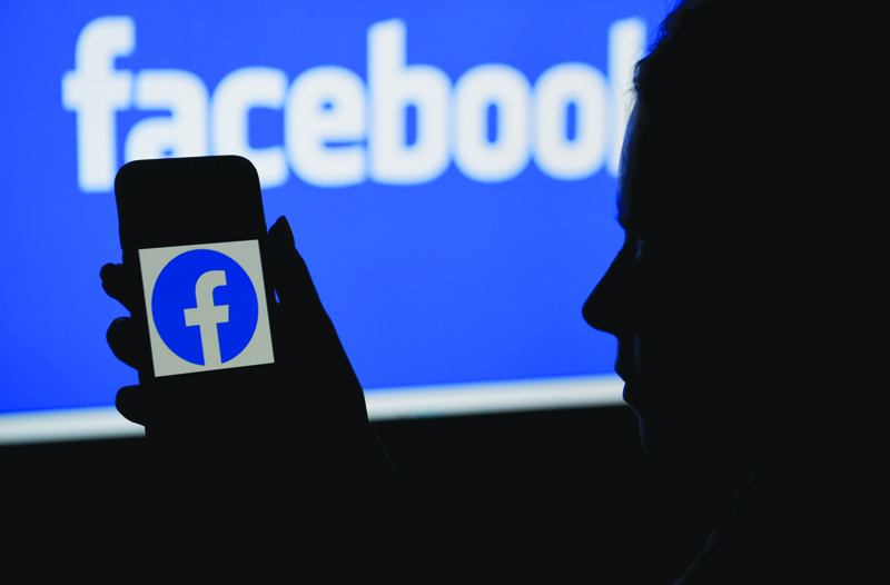 NEW YORK: In this file photo illustration, a smart phone screen displays the logo of Facebook on a Facebook website background in Arlington, Virginia. - AFPnn