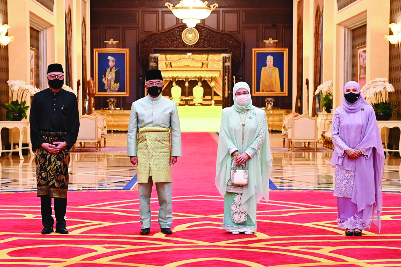 KUALA LUMPUR: This handout photo from the Malaysia National Palace taken and released yesterday shows Malaysia's Prime Minister Ismail Sabri Yaakob (L) and his wife Datin Sri Muhaini binti Zainal Abidin (R) posing for pictures with Malaysia's King Sultan Abdullah Sultan Ahmad Shah (2nd L) and Queen Tunku Azizah Aminah Maimunah Iskandariah (2nd R) after a swearing-in ceremony for the incoming prime minister at the National Palace in Kuala Lumpur. -AFPn