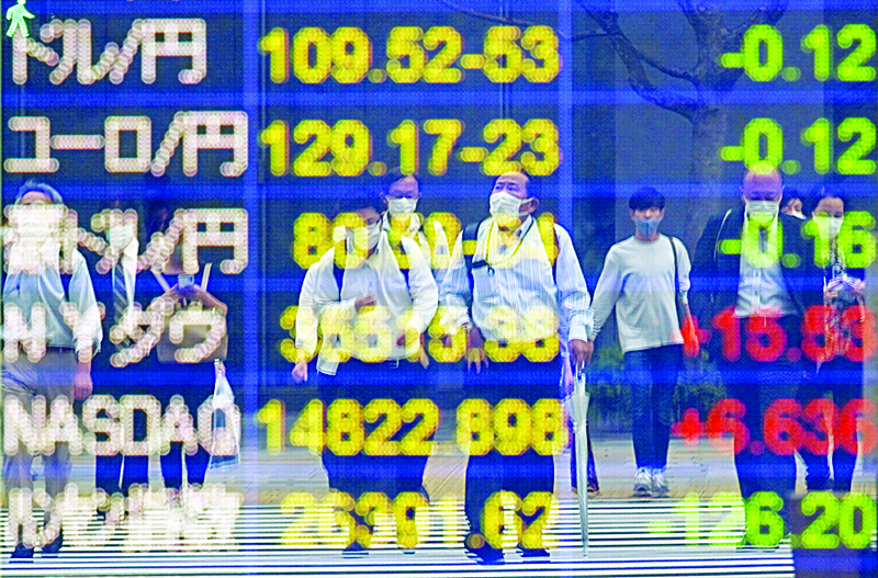 TOKYO: Passers-by are reflected on the electric bulletin board showing the foreign exchange rate, including Yen rate against the US dollar (top) in Tokyo.-AFPnn