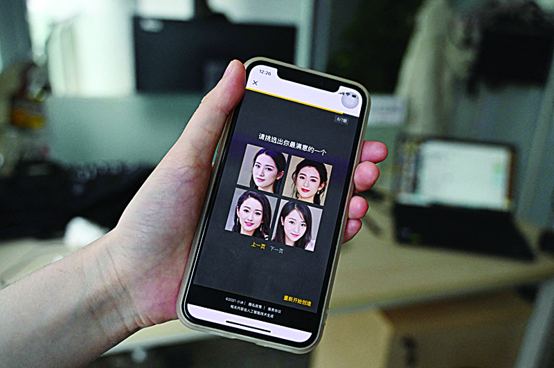 BEIJING: File photo shows a staff member displaying AI-generated faces which can be selected as virtual girlfriends created by XiaoIce, a cutting-edge artificial intelligence system designed to create emotional bonds with its 660 million users worldwide. - AFPn