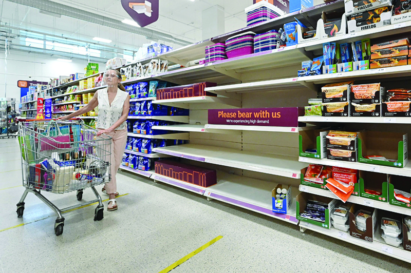 LONDON: File photo shows a shopper walks past a sign advising that products are temporarily out of stock is displayed in a supermarket at Nine Elms, south London on July 22, 2021. - AFPn