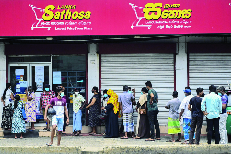 COLOMBO: People queue outside a supermarket in Colombo yesterday following Sri Lanka's declaration of state of emergency over food shortages as private banks ran out of foreign exchange to finance imports. - AFPn