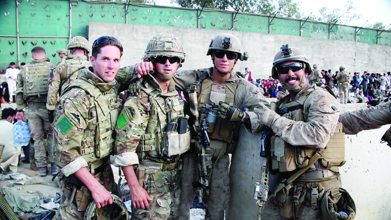 KABUL: A handout picture released by the British Ministry of Defense (MOD) shows members of the British (left) and US Armed Forces posing for a photograph while working at Kabul Airport Sunday. - AFPnn