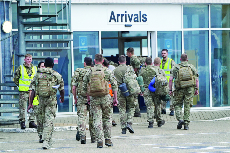 BRIZE NORTON, UK: Members of the British armed forces 16 Air Assault Brigade walk to the air terminal after disembarking a Royal Air Force Voyager at RAF Brize Norton, west of London yesterday.-AFPn