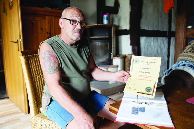 QUENTEL, Germany: Andreas Braeutigam, veteran of the German army Bundeswehr who served in Afghanistan for eight months in 2003-2004 and whose last name was Roehrig before his marriage, shows a certificate he was given during his deployment, at his home in Quentel (Hessisch-Lichtenau), central Germany.-AFPn