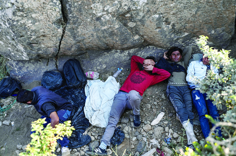 TATVAN, Turkey: Afghan migrants rest while they wait for transport by smugglers after crossing the Iran-Turkish border in Tatvan, on the western shores of Lake Van, eastern Turkey. - AFPnn