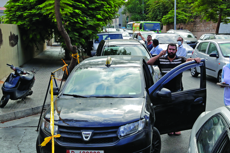 BEIRUT: Lebanese wait in a queue outside a closed petrol station in Beirutfs Hamra district Friday.-AFPn