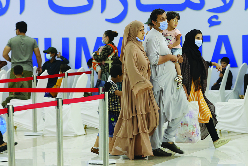 ABU DHABI: Refugees who fled Afghanistan gather at the International Humanitarian City (IHC) in Abu Dhabi as they wait to be transferred to another destination yesterday.-AFPn