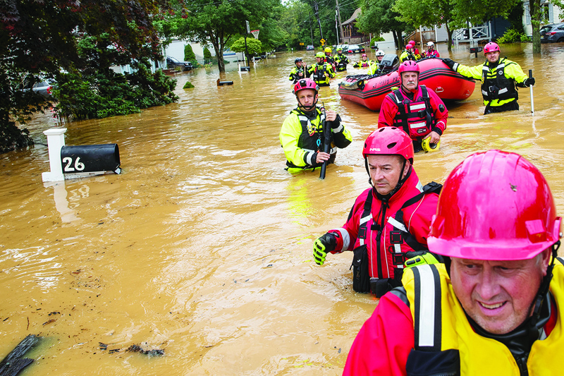 HELMETTA, US: Members of the New Market Volunteer Fire Company perform a secondary search during an evacuation effort following a flash flood as Tropical Storm Henri makes landfall in Helmetta, New Jersey, Sunday.-AFPn
