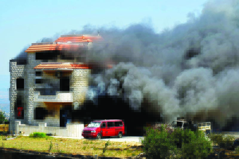 Smoke billows from the reported home of the lot owner where a fuel tank that exploded was placed in the village of Tlel in Lebanon's northern region of Akkar yesterday. - AFP n