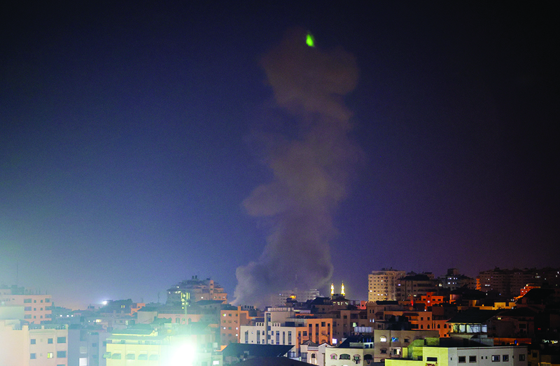 GAZA CITY: Explosions light up the night sky above buildings in Gaza City as Zionist forces shell the Palestinian enclave early yesterday. - AFPn