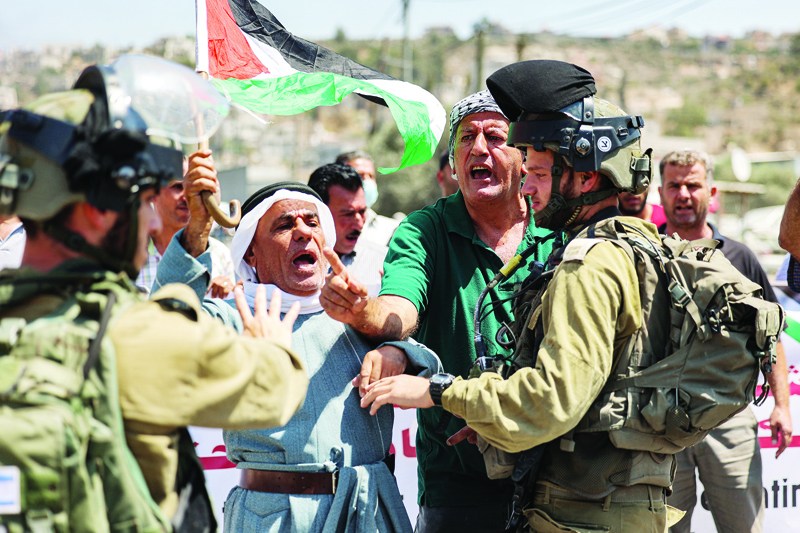 BEITA, Palestinian Territories: Palestinian locals from the village of Beita in the north of occupied West Bank yesterday argue with Zionist soldiers as they protest against the creation of a new road for Jewish settlers.—AFPn