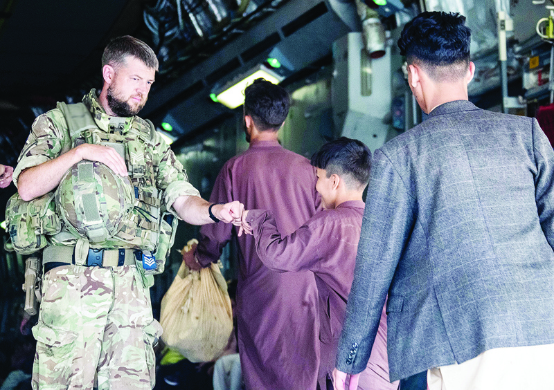 KABUL: A handout picture released by the British Ministry of Defense shows a member of the UK Armed Forces fist-bumping an evacuee during their deployment to support the evacuation of British nationals and entitled personnel at Kabul airport in Afghanistan. – AFPn