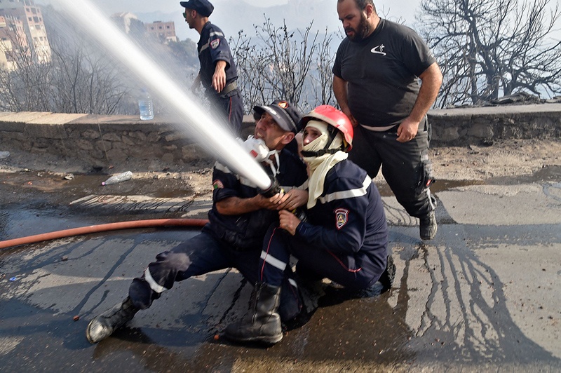 Firefighters battle flames in the forested hills of the Kabylie region east of the capital Algiers yesterday. – AFP n